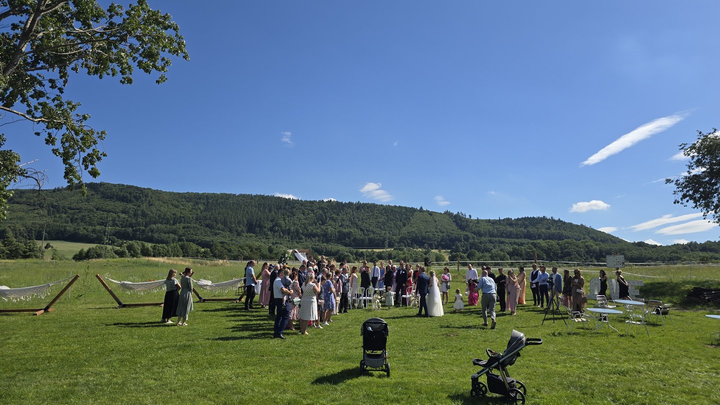 Goście na łące w trakcie ceremonii, wzgórza